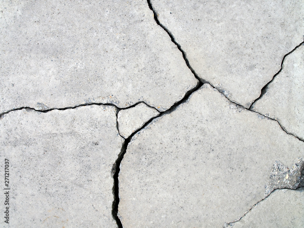 Obraz premium detail of fractured concrete sidewalk floor, gray grunge cement surface with large cracks, earthquake effect causes ground and building wall to damaged, abstract texture background, close up top view