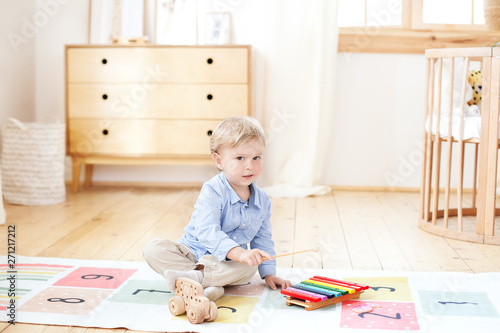 The boy plays in a kindergarten on the xylophone. boy playing with toy musical instrument xylophone in the children's room. Close-up of a kid playing on xylophone. The concept of child development.