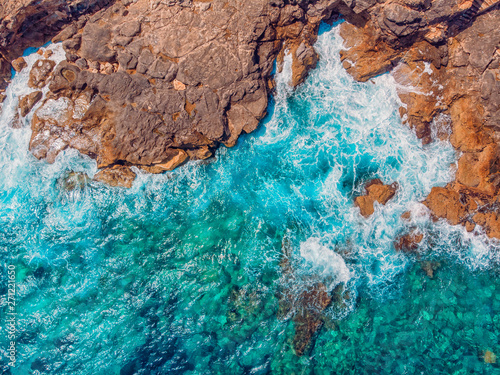 Azure clear water hits the rocky coast of coral beach. Aerial top view © Parilov