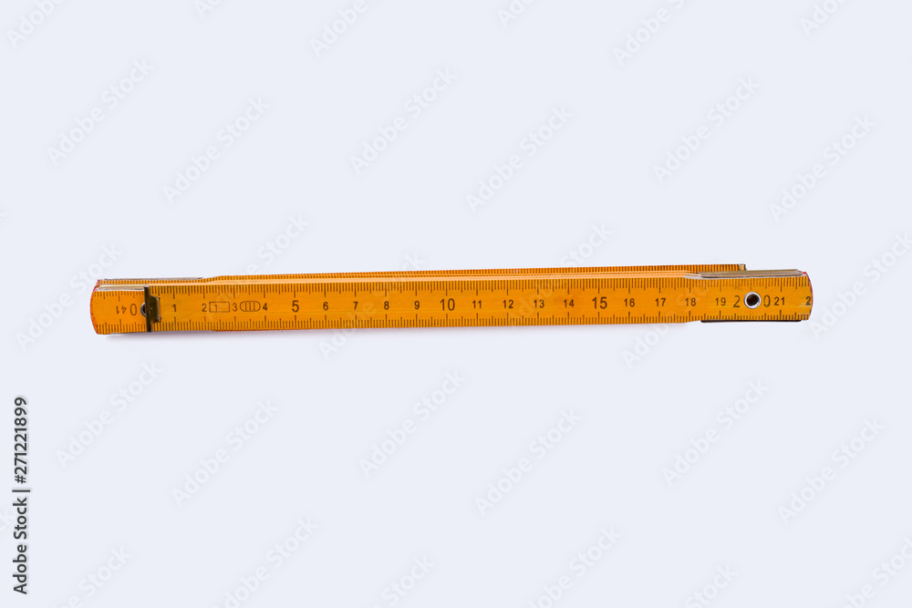 Yellow folding ruler isolated on white background. Wooden measuring tool for carpenter. Yellow folding ruler isolated on white background. Wooden measuring tool for carpenter.