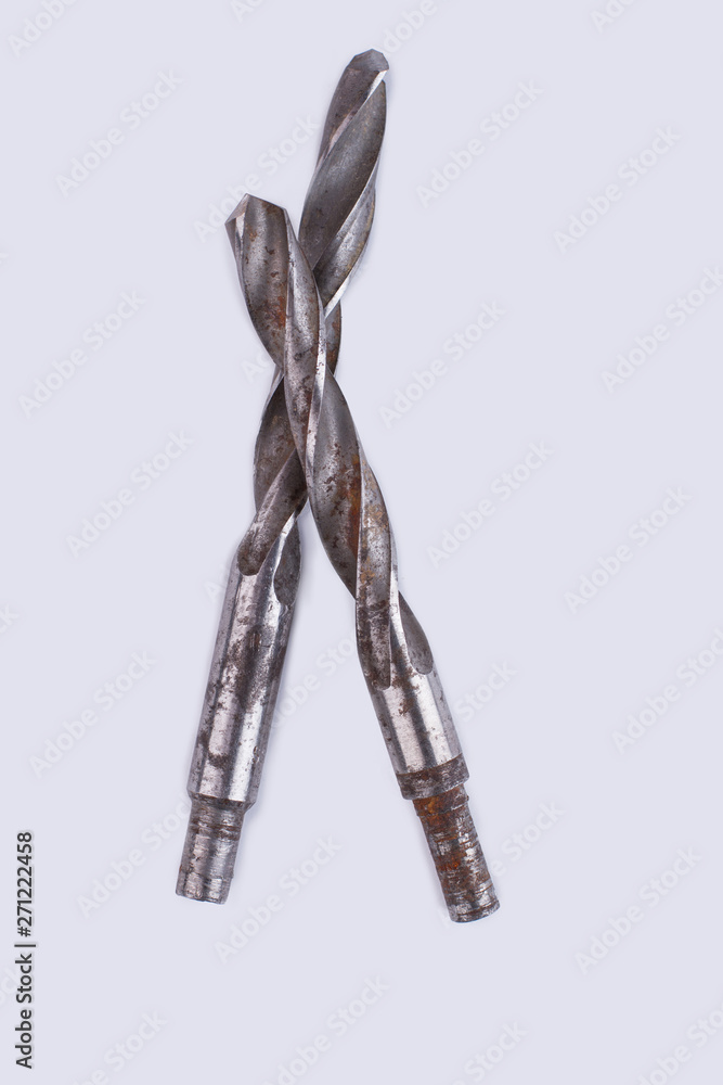 Rusty drill bits over white background. Two old drill bits, vertical image.