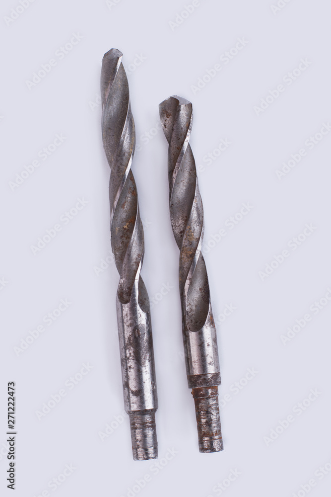 Old drill bits, top view. Used metal tools isolated on white background. Old drill bits, top view. Used metal tools isolated on white background.
