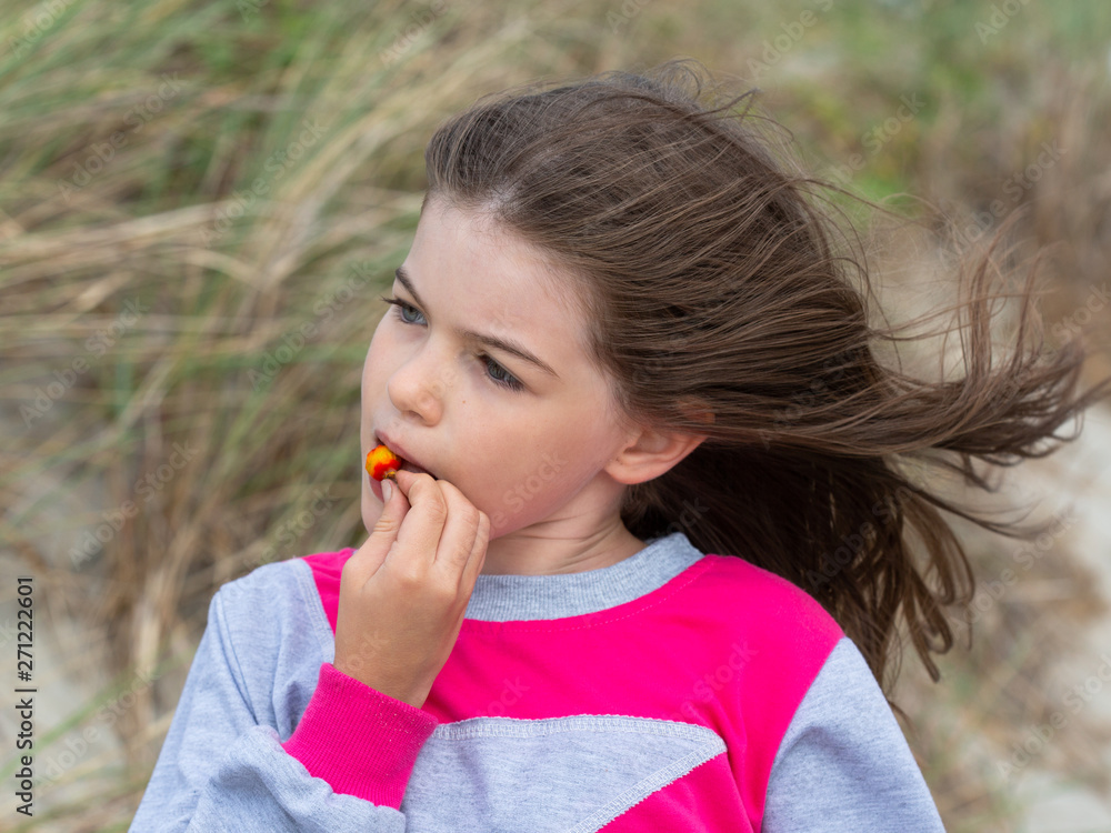 Fototapeta premium little cute girl eating rosehip