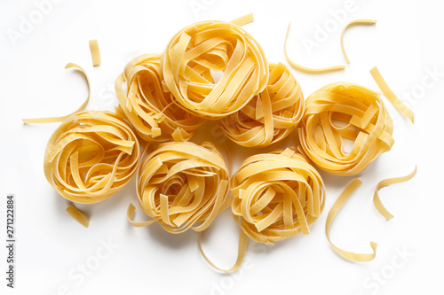 dry uncooked fettuccine on a white background