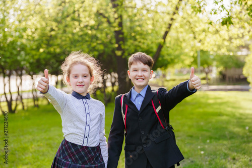 Happy school children giving a thumbs up