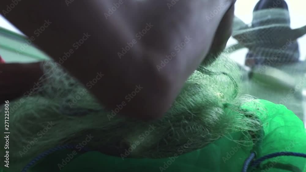 Fisherman preparing fish net for fishing in sea water. Fishing net close up. Equipment for catching fish. Fisherman preparing fish net for fishing in sea water. Fishing net close up. Equipment for catching fish.