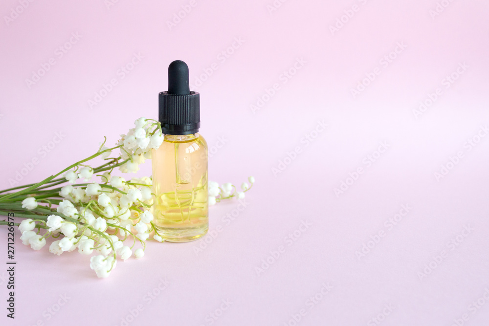 Cosmetic oil in a bottle of drip, on a pink background. Lily of the Valley Essential Oil Cosmetic oil in a bottle of drip, on a pink background. Lily of the Valley Essential Oil