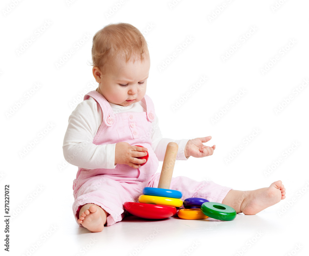 Adorable baby playing enthusiastically woth educational toy. Small kid sits on floor, isolated on white background Adorable baby playing enthusiastically woth educational toy. Small kid sits on floor, isolated on white background