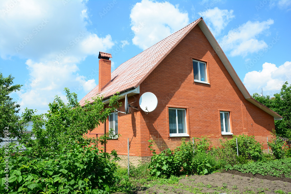 Cozy brick house with antenna and metal roof