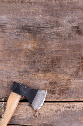 Axe on vintage wooden background. Tool on old wooden boards. Top view with copy space.