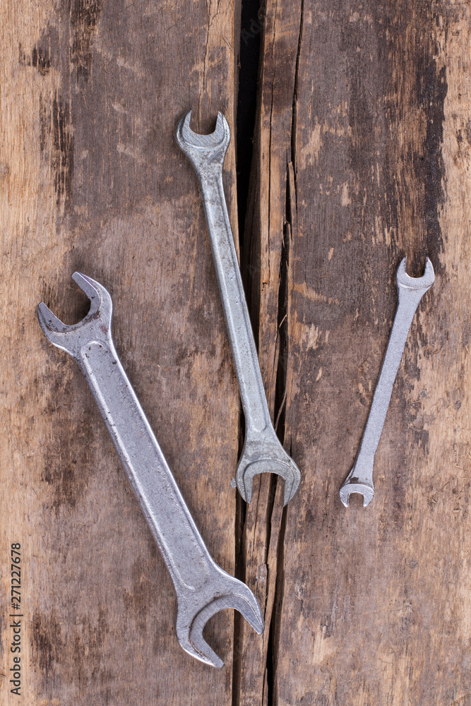 Wrenches on old wooden boards background. Tools on rustic planks, top view. Wrenches on old wooden boards background. Tools on rustic planks, top view.