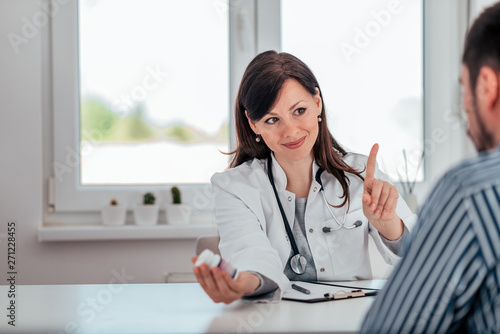 Portrait of female doctor explaining how to take prescribed medication to a patient.