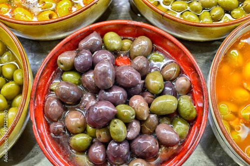 Marinated olives with herbs in a market.