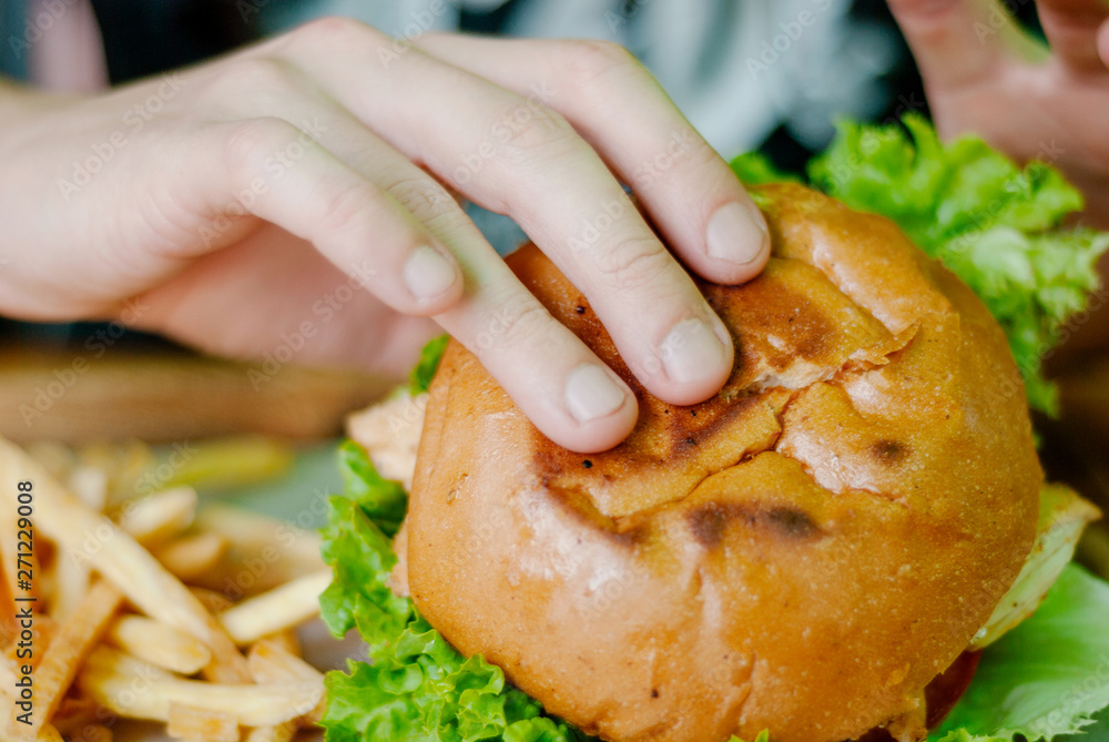 Man in a restaurant eating a hamburger, he is hungry and having a good bite. selective focus Man in a restaurant eating a hamburger, he is hungry and having a good bite. selective focus
