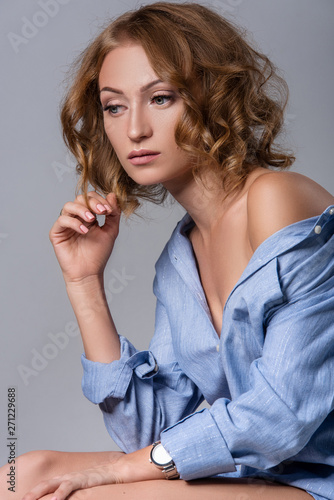 Blonde in shirt posing in a white studio