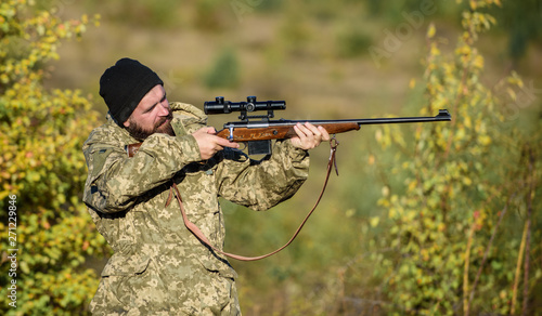 Regulation of hunting. Hunter hold rifle. Bearded hunter spend leisure hunting. Focus and concentration of experienced hunter. Hunting masculine hobby concept. Man brutal gamekeeper nature background