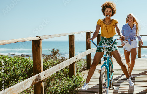 Girls having fun with bike on boardwalk