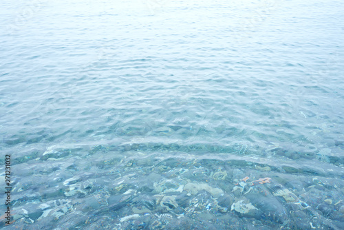 Background shot of aqua sea water surface with pebbles