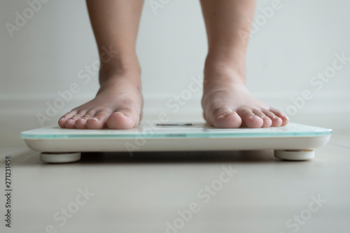 Woman is checking weight by using weight checking machine.