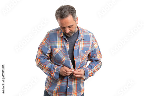 Man buttoning up shirt