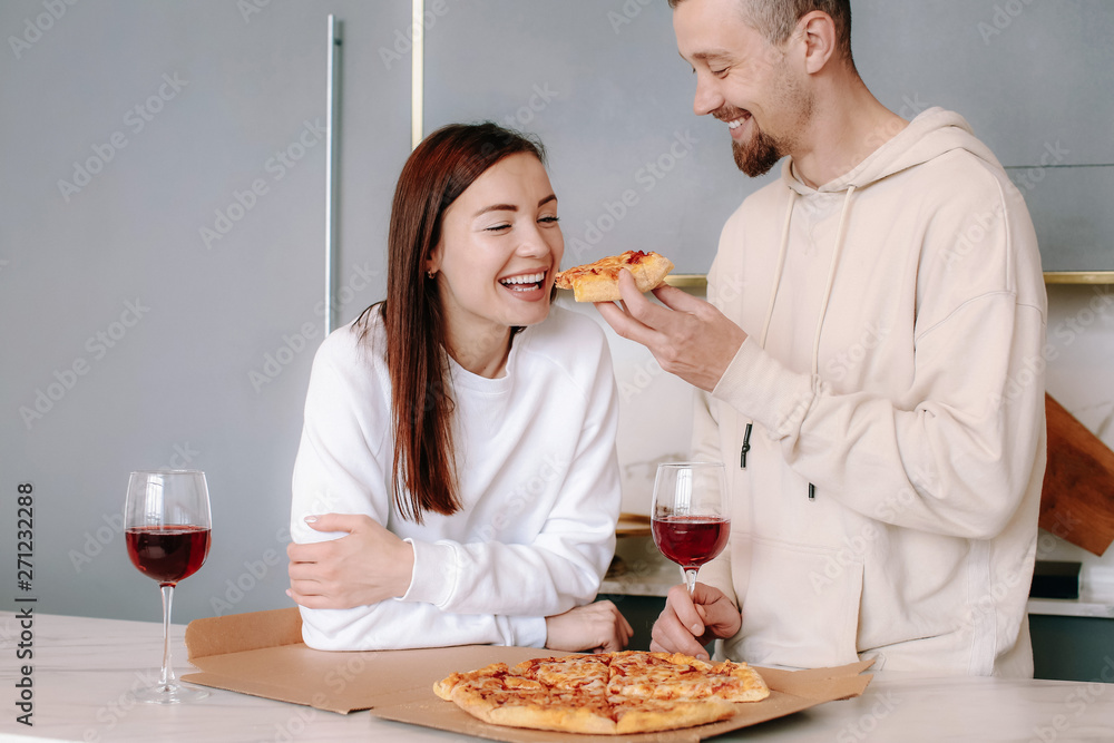 Happy couple drinking wine and eating tasty pizza at home Happy couple drinking wine and eating tasty pizza at home