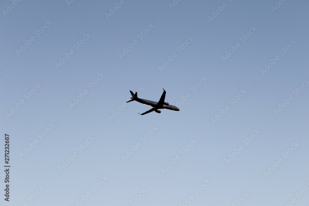 Airplane flying in dark blue evening sky. Plane on pure sky background Airplane flying in dark blue evening sky. Plane on pure sky background
