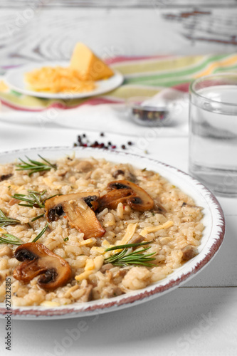 Plate with tasty risotto on white table