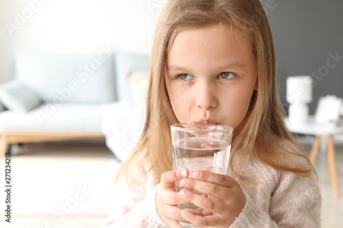 Cute little girl drinking w...