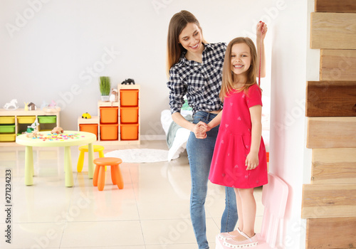 Young mother measuring heig...