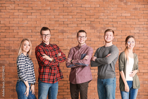 Group of young business people on brick background