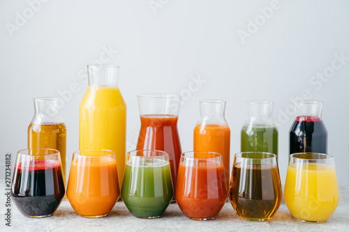 Cold organic fruit juice in glass jars against white background. Healthy drink concept. Homemade beverage containing vitamins