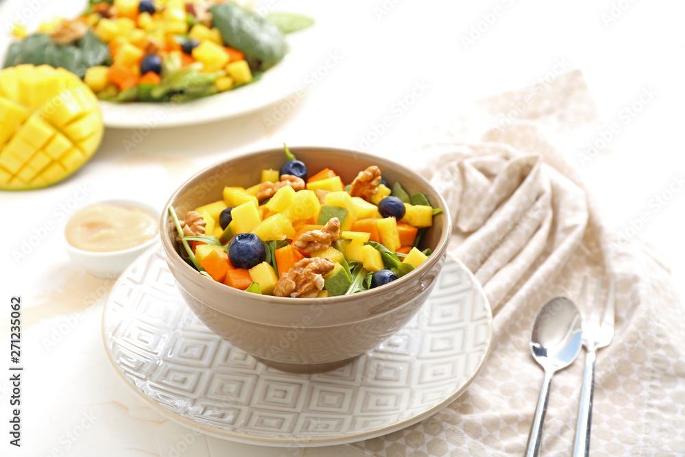 Bowl with tasty mango salad on light table Bowl with tasty mango salad on light table