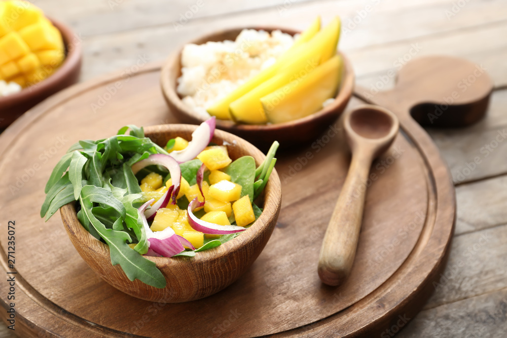 Bowl with tasty mango salad on wooden table Bowl with tasty mango salad on wooden table