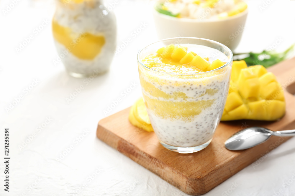 Glass of tasty mango dessert on white table Glass of tasty mango dessert on white table