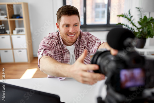 Schilderij op canvas blogging, videoblog and people concept - male video blogger adjusting camera at