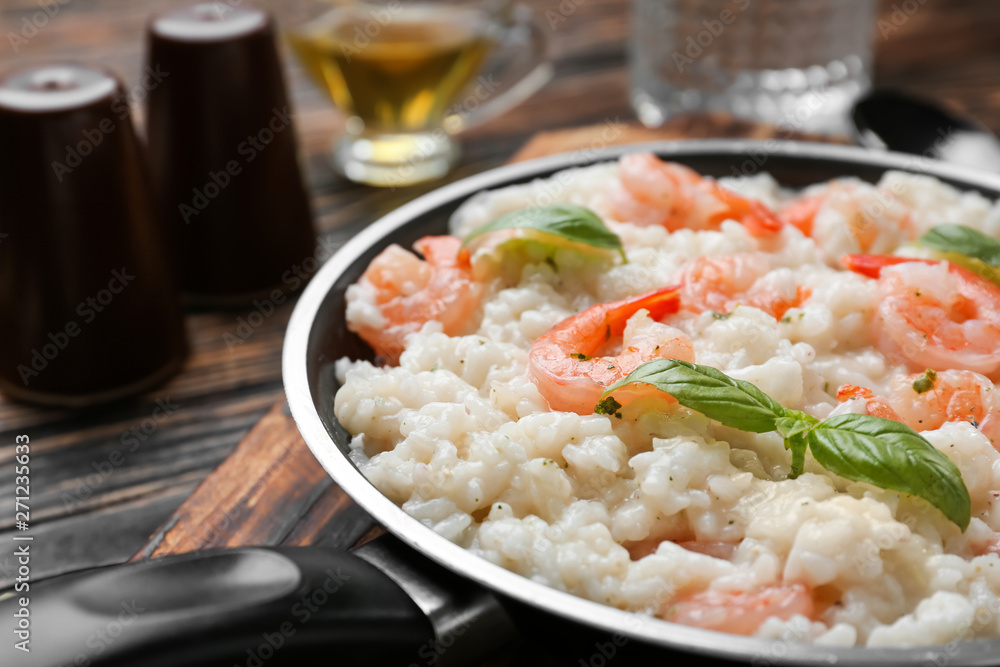 Frying pan with tasty risotto on table, closeup Frying pan with tasty risotto on table, closeup