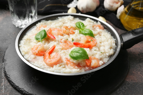 Frying pan with tasty risotto on table