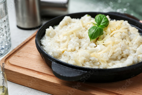Frying pan with tasty risotto on table