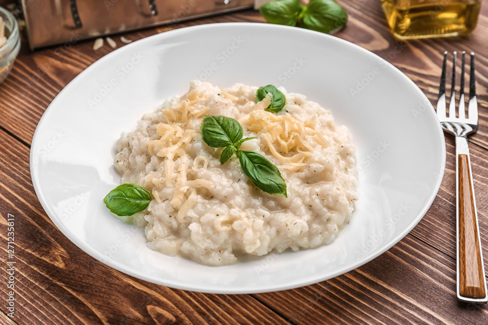 Plate with tasty risotto on wooden table