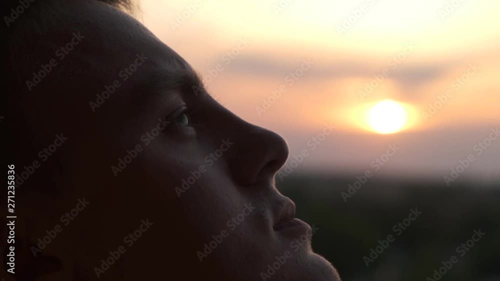 A man looks at the sky at sunset, close. up. Concept of prayer and faith A man looks at the sky at sunset, close. up. Concept of prayer and faith