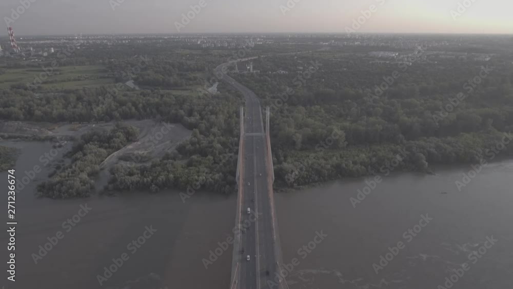 Panoramic aerial view of Warsaw Siekierkowski Bridge with the river in the background. Flying over the river hung through a busy road. Warsaw downtown on the background at sunset. 4K drone in RAW. Panoramic aerial view of Warsaw Siekierkowski Bridge with the river in the background. Flying over the river hung through a busy road. Warsaw downtown on the background at sunset. 4K drone in RAW.