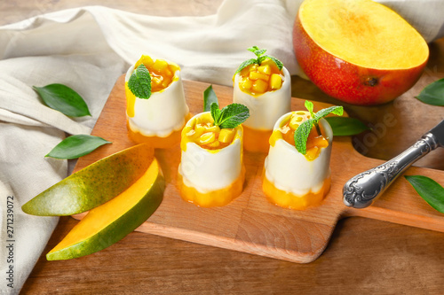 Board with tasty mango dessert on table