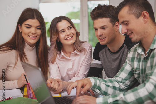 Friendship, youth concept. Lovely young cheerful female student smiling joyfully at her friends, enjoying studying together. University students preparing for an exam