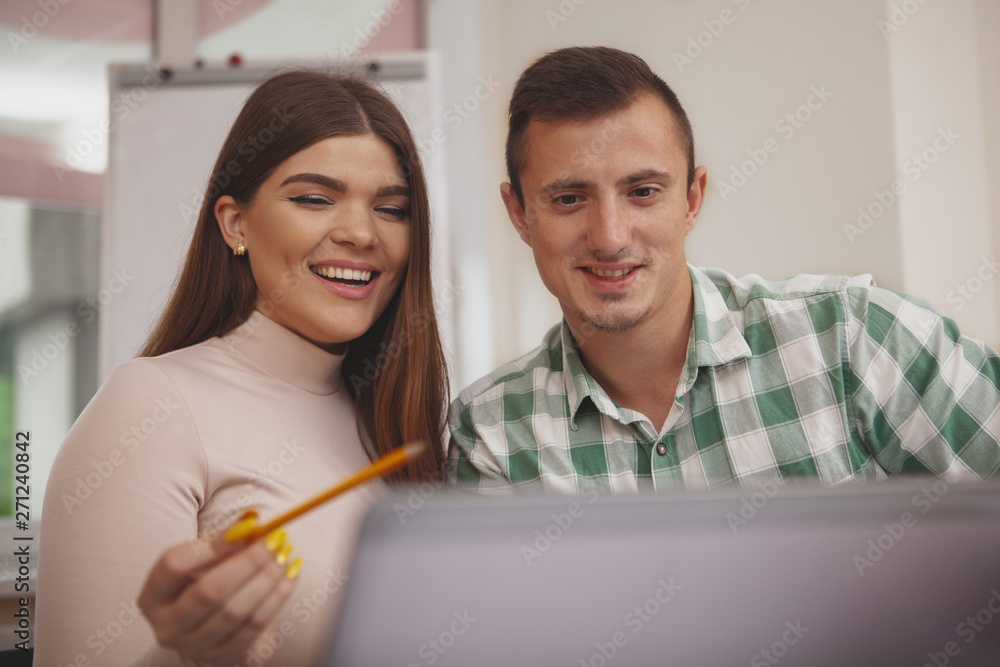 Friends, college lifestyle concept. Happy beautiful young woman laughing joyfully, studying online with her boyfriend. Cheerful students browsing online, preparing for exams Friends, college lifestyle concept. Happy beautiful young woman laughing joyfully, studying online with her boyfriend. Cheerful students browsing online, preparing for exams