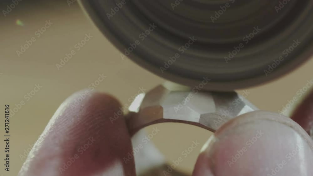 Male jewellery creator hand polishing and buffing a gold or platinum