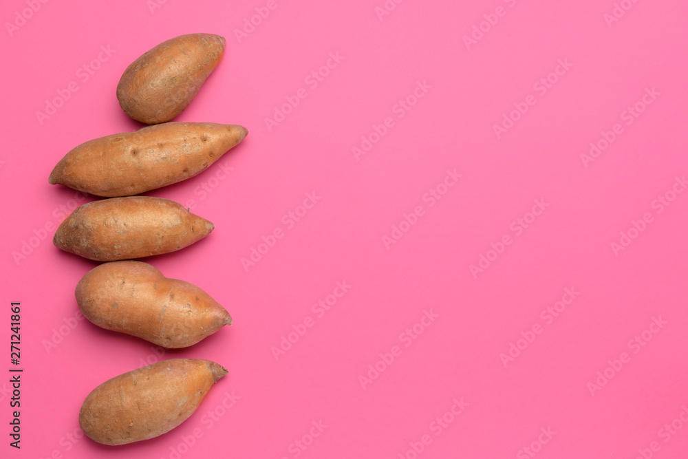 Obraz premium Fresh sweet potatoes on color background