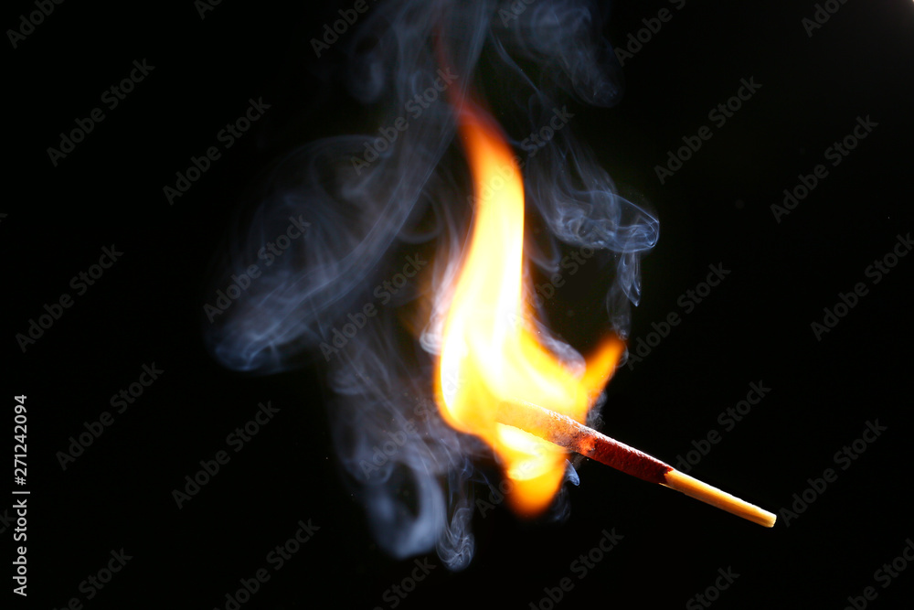 Burning match on dark background Burning match on dark background