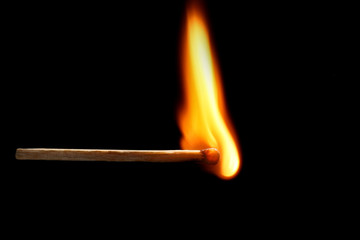 Burning match on dark background