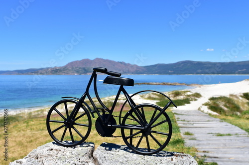 Beach with black iron bicycle. Galicia, Spain.