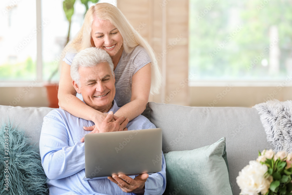 Portrait of happy mature couple with laptop at home Portrait of happy mature couple with laptop at home